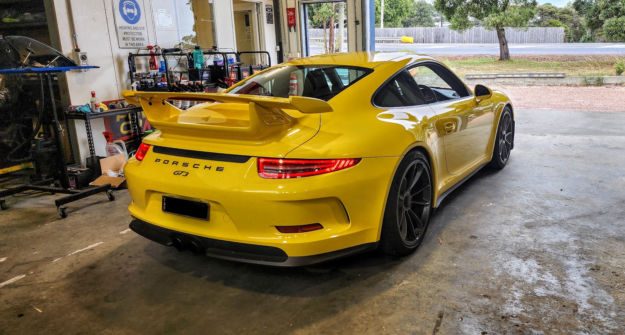 A yellow Porsche 911 GT3 inside the Subaru Mechanical workshop